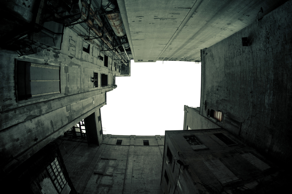 View of the sky from deep inside a dismal interior courtyard