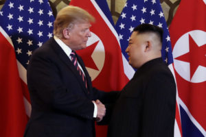 President Donald Trump shakes hands with North Korean leader Kim Jong Un.