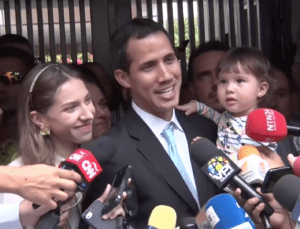 A man and his family surrounded by microphones.