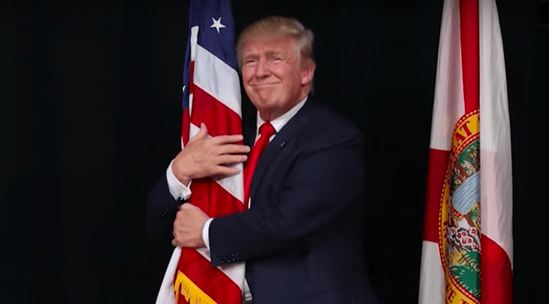 Donald Trump hugging a flag.