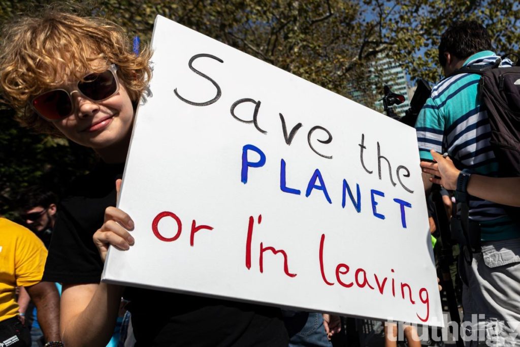 a sign at a protest reads 'Save the planet or I'm leaving'