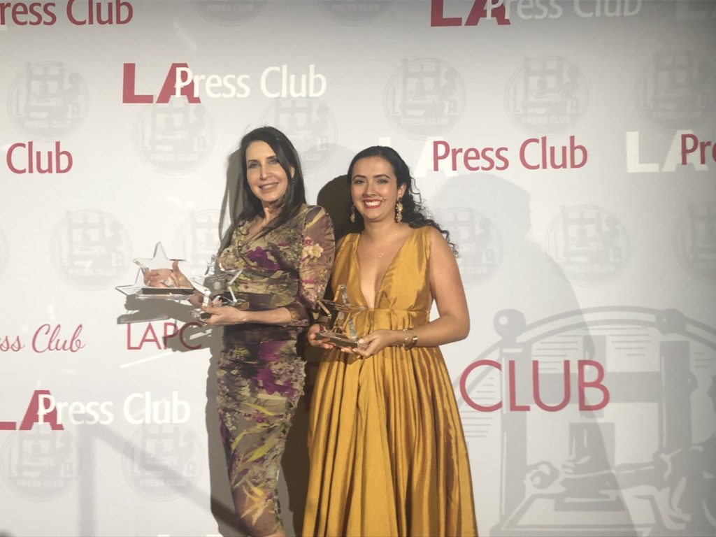 two women holding awards