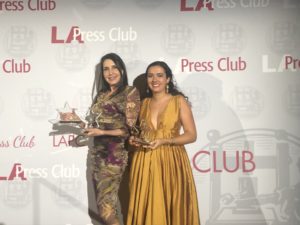 two women holding awards