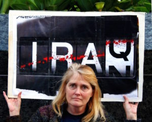 A protester holds a sign that reads "Iraq" and "Iran."