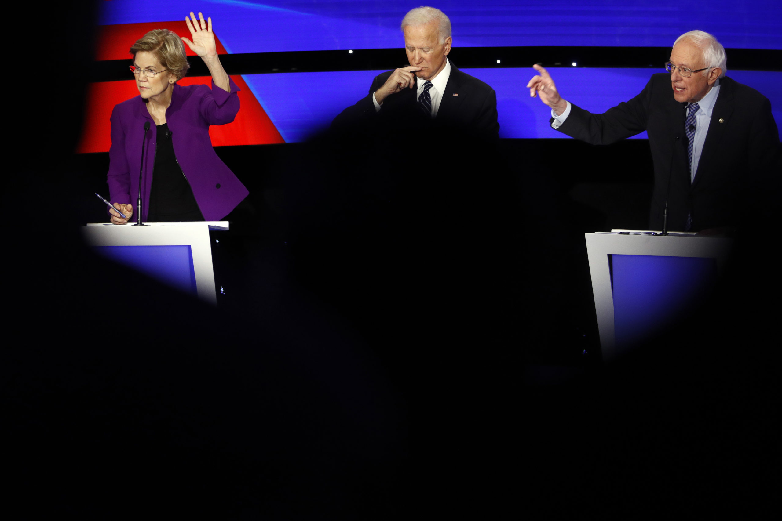 Three Democrats at on a debate stage.