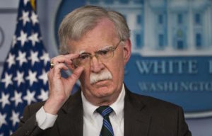 John Bolton adjusts his glasses.