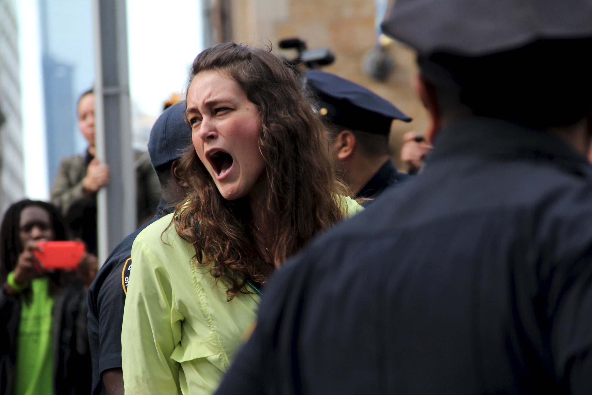 A protester surrounding by police officers.