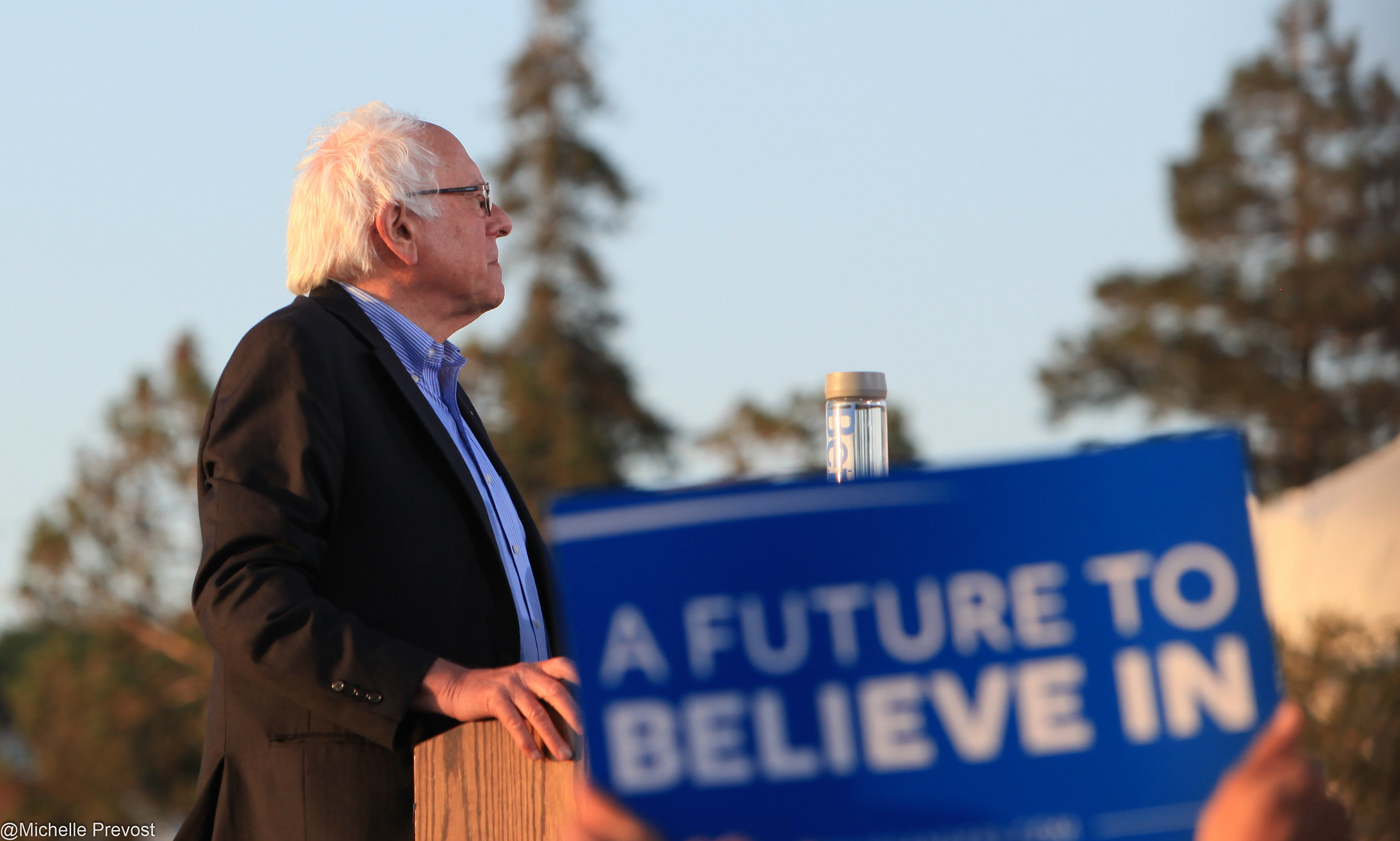 Bernie Sanders stands on a podium.