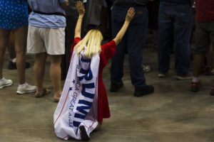 A supporter kneels during a Trump rally in 2016.
