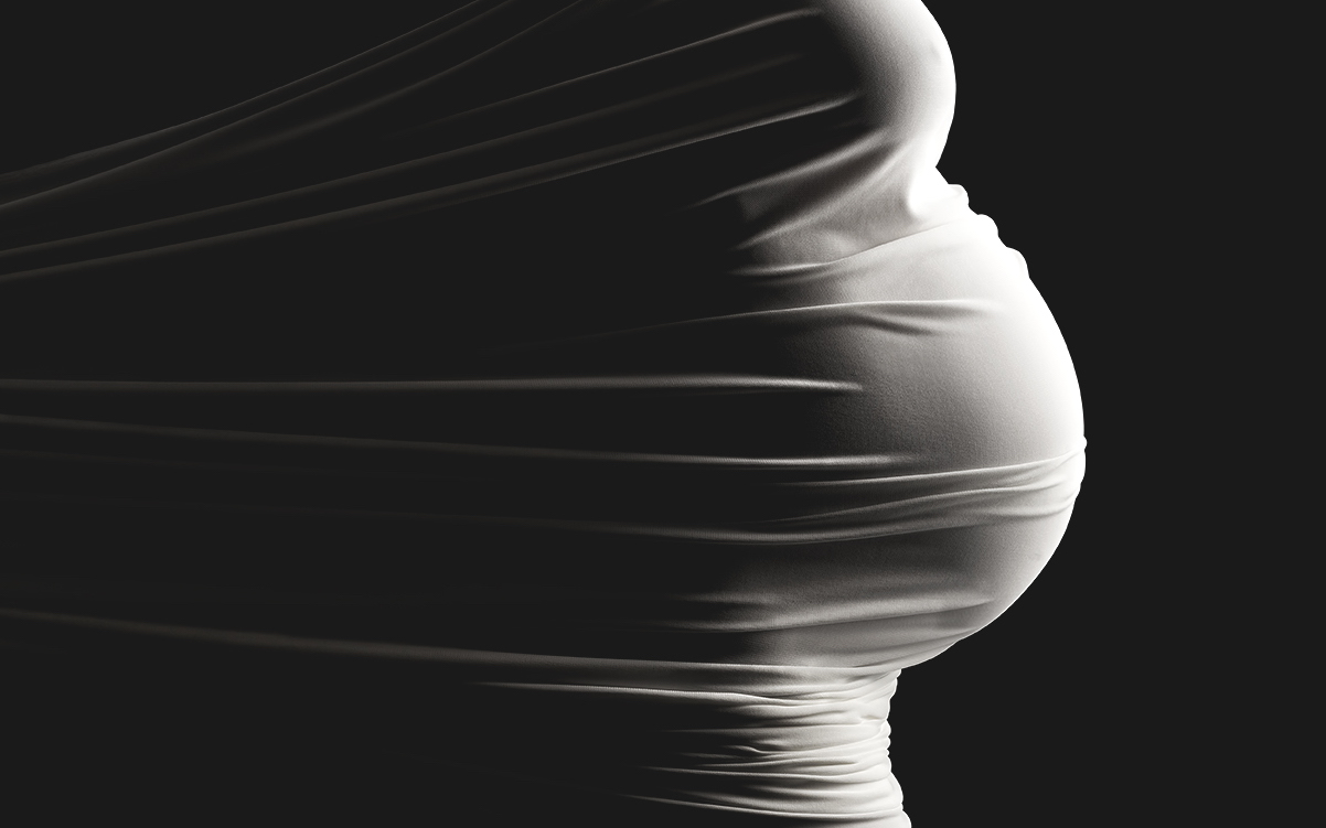A pregnant woman wrapped in a white sheet.