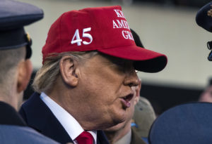 Donald Trump wearing a red baseball cap with the number 45 in white on the side.