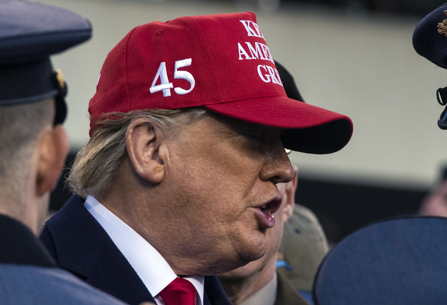 Donald Trump wearing a red baseball cap with the number 45 in white on the side.
