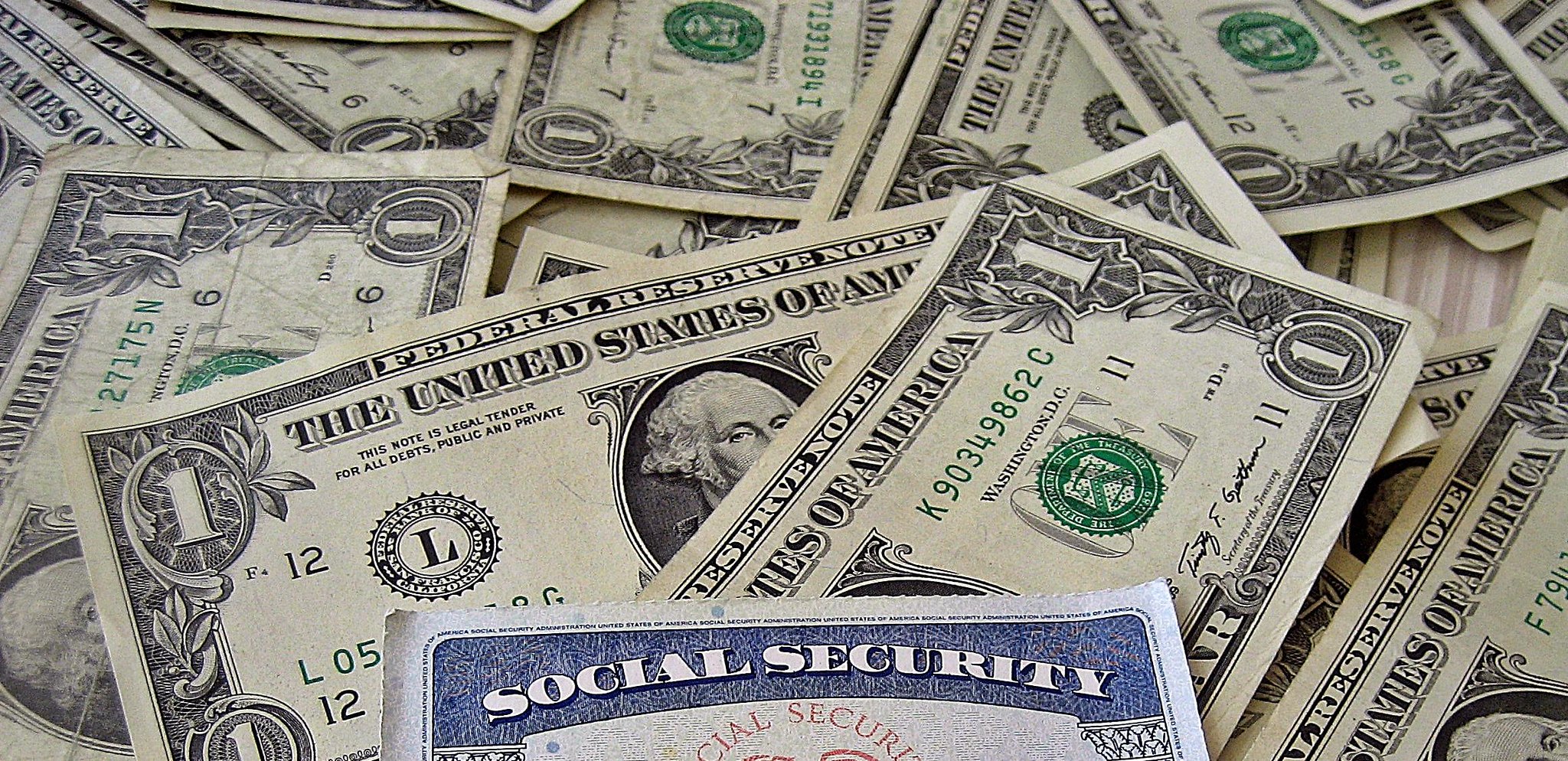 Piles of dollar bills and a social security card.