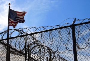 American flag flying above barbed wire