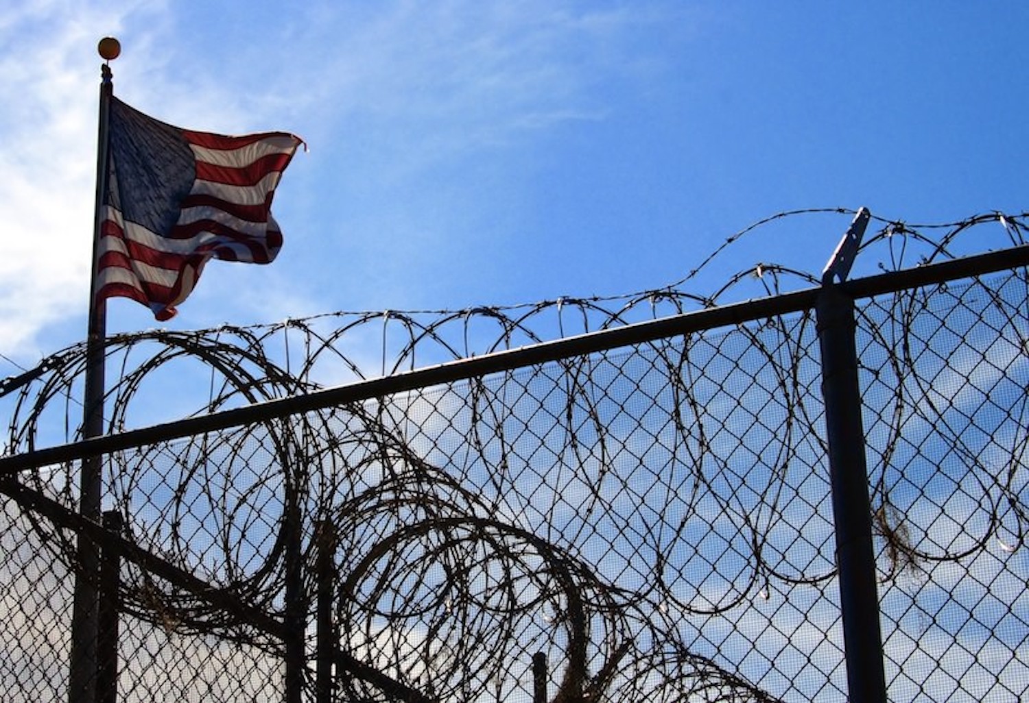 American flag flying above barbed wire