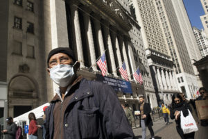 Man wearing mask in front of New York Stock Exchange building